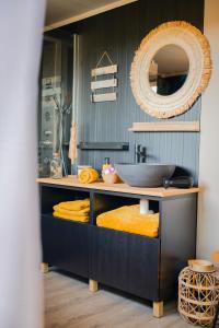 a bathroom with a counter with a sink and a mirror at le ptit couki in Chimay