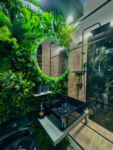 a bathroom with a sink and a mirror and plants at Luxury apartament40 in Craiova