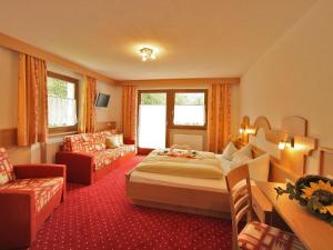 una camera d'albergo con letto e divano di Hotel Gisserhof a San Giovanni in Val Aurina