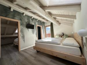 利维尼奥Garni La Casetta的房间里有一张床和一台电视的卧室