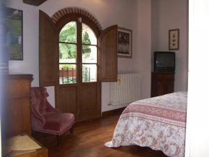 a bedroom with a bed and a dresser and a window at Campomaggio in Pistoia