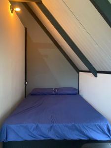 a bedroom with a blue bed in a attic at Cabanas Sudarê na Praia do Rosa in Imbituba