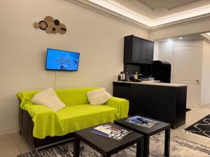 a living room with a yellow couch and a kitchen at luxury studio archit 14 street in Patra