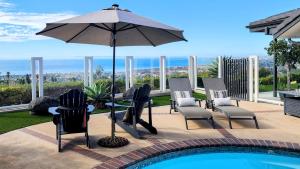 een patio met stoelen en een parasol naast een zwembad bij Ocean Views Beach House - 40 PCT Off Monthly in San Clemente