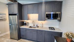 een keuken met grijze kasten en een roestvrijstalen koelkast bij Ocean Views Beach House - 40 PCT Off Monthly in San Clemente