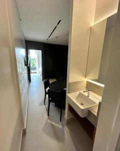 La salle de bains est pourvue d'un lavabo, d'une table et d'une chaise. dans l'établissement GAV PORTO ALTO RESORT- Muro Alto, à Porto de Galinhas