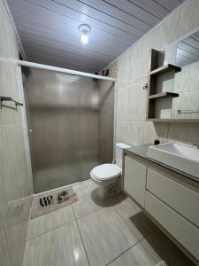 a bathroom with a shower and a toilet and a sink at Casa a 900m do Beto Carrero in Penha