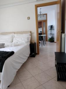 una camera con un grande letto bianco e un soggiorno di Da Lellina ad Arezzo