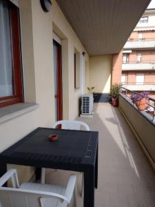un tavolo nero e sedie bianche su un balcone di Da Lellina ad Arezzo