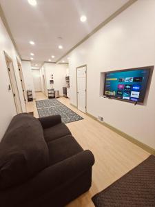 a living room with a couch and a flat screen tv at New! Golden Getaway walk to the falls in Niagara Falls
