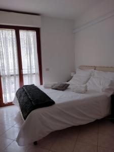 un grande letto bianco in una stanza con due finestre di Da Lellina ad Arezzo