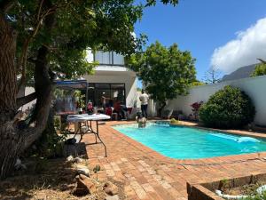 a swimming pool with a table and two dogs in it at Heaven in Cape Town