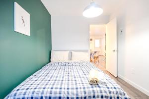 a bedroom with a bed with a plaid bedspread on it at Cozy 2-Bedroom in Griffintown in Montréal