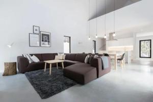 a living room with a brown couch and a table at Villa Boreale - Wellness and relaxation in Petite-Rivière-Saint-François