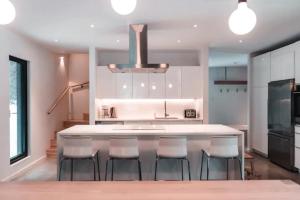 a kitchen with a large island with bar chairs at Villa Boreale - Wellness and relaxation in Petite-Rivière-Saint-François