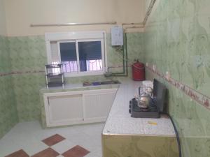 una cucina con piano di lavoro e finestra di شقة للكراء اليومي بمركز تنغير a Tinerhir