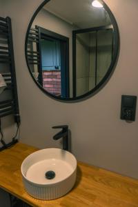 a bathroom with a circular mirror on a wooden counter at Balia pod lasem in Stara Łomnica