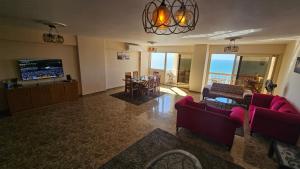 a living room with a couch and a table and a television at Midpoint Panoramic View - Families Only in Alexandria