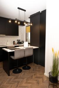 a kitchen with black cabinets and a white counter top at Green Urban Studio in Târgu-Mureş