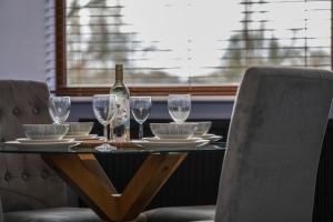 a table with glasses and a bottle of wine on it at Oak View Lodge - Deluxe Master Studio near Ipswich & Woodbridge in Playford