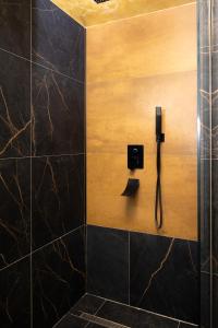 a bathroom with a shower with a phone on the wall at Green Urban Studio in Târgu-Mureş