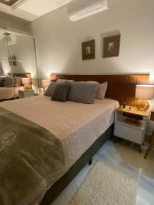 ein Schlafzimmer mit einem großen Bett und einem Spiegel in der Unterkunft Casa aconchegante - Green Village - Praia do Cassino in Rio Grande