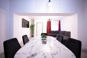 a dining room with a marble table and chairs at Apartalux Premium Suites in Grao de Castellón