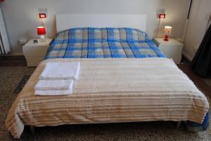 Un dormitorio con una cama con dos mesitas de noche y dos lámparas. en Alloggio turistico, en Pisa