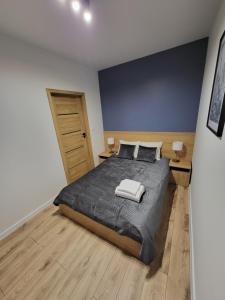ザモシチにあるApartament - Monte Cassino 1の大きなベッドと2つのナイトスタンドを備えた寝室