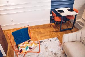 a living room with a chair and a table at Azimut art apartman in Bijeljina