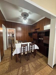 a dining room with a table and a piano at La Casa de la Nona Elisa in Mar del Plata