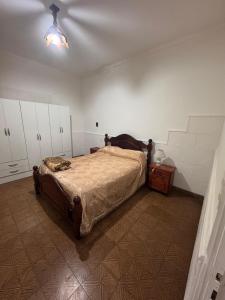 a bedroom with a bed and a dresser and a ceiling at La Casa de la Nona Elisa in Mar del Plata