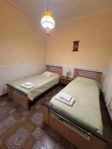 two twin beds in a room with a lamp at La Casa de la Nona Elisa in Mar del Plata