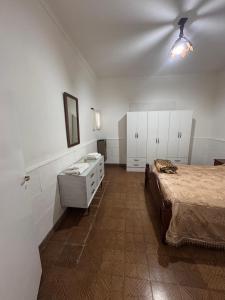 a bedroom with a bed and a dresser in it at La Casa de la Nona Elisa in Mar del Plata