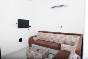 ein Wohnzimmer mit einem Sofa und einer Schachtel in der Unterkunft Al Jumhour Hotel Apartments in Sur