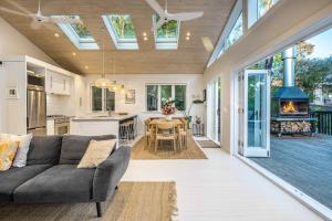 Waiheke IslandにあるSkyview Onetangi - Stay Waihekeのリビングルーム(ソファ付)、キッチン(暖炉付) +19枚の写真
