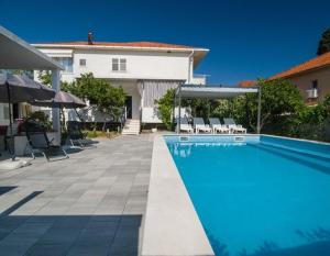 a swimming pool in front of a house at Apartments Boris in Orebić