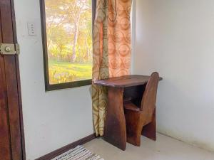 a wooden chair sitting in front of a window at Hospedaje Shaddai in Palo