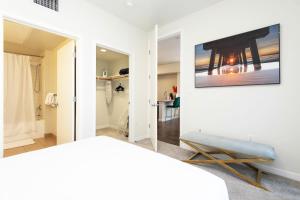 a bedroom with a white wall with a mirror at ViewPoint Suites in Los Angeles +163 photos