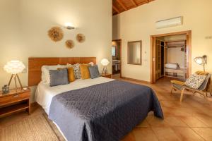 a bedroom with a large bed and a chair at Villa Monte Santo Estevão in Silves +93 photos