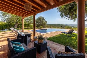a patio with chairs and a swimming pool at Villa Monte Santo Estevão in Silves