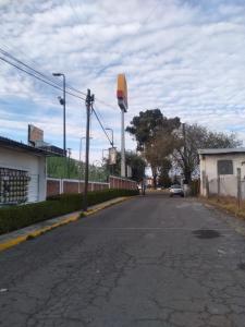 an empty street with a car driving down the road at Cómoda habitación para descanso, La casa del artista in Toluca