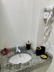a bathroom counter with a sink and a phone at The Garden 103 - paz e sofisticação - 2 quartos ar condicionado in Cascavel