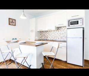 a kitchen with white cabinets and white appliances at La casita de Ohana in Costa Teguise +2 photos