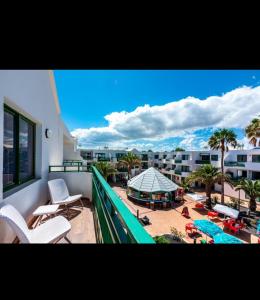 a balcony with a view of a pool and a resort at La casita de Ohana in Costa Teguise