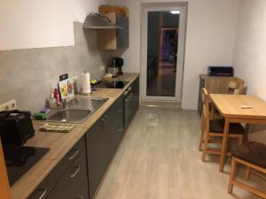 a small kitchen with a sink and a table at Ferienwohnung Ehrenfriedersdorf 18 in Ehrenfriedersdorf