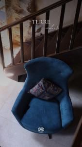 a blue chair with a pillow on it next to a bed at Batroun Old Town private duplex with garden in Batroûn