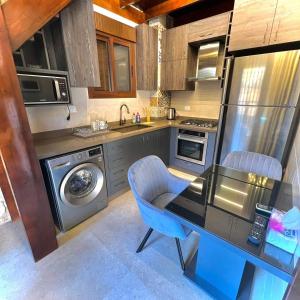 a kitchen with a table and a washing machine at Batroun Old Town private duplex with garden in Batroûn