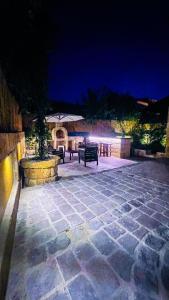 two benches sitting on a stone patio at night at Batroun Old Town private duplex with garden in Batroûn