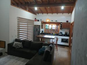 a living room with a couch and a kitchen at Casa Super Astral no Sul da Ilha in Florianópolis